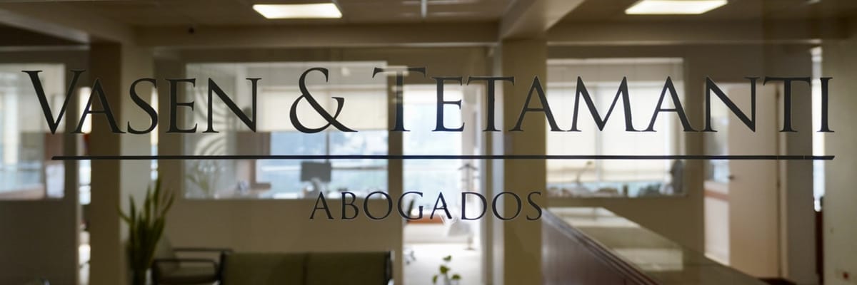 Cartel de Vasen & Tetamanti Abogados en el vidrio de la oficina, con el estudio detrás